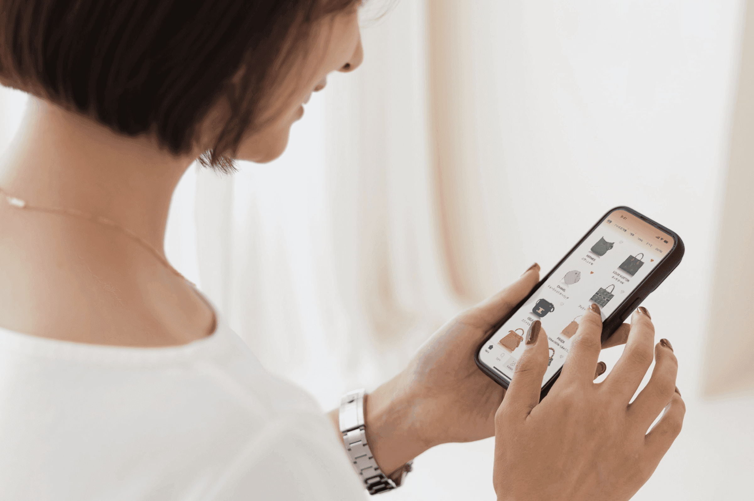 スマートフォンのアプリでバッグを選ぶ手元